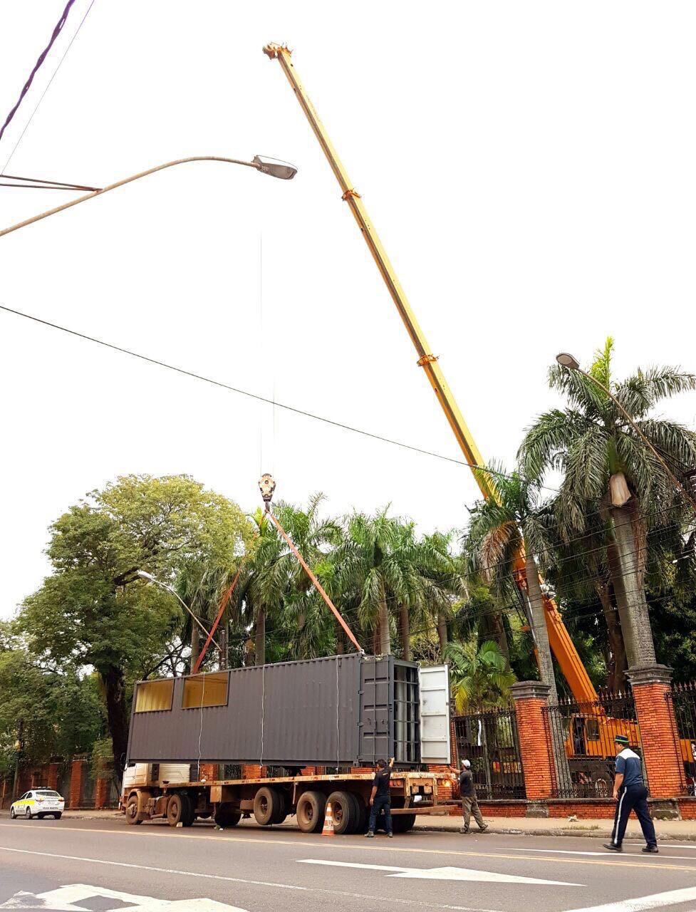 Grúa propia izando un módulo sobre el camión en la calle